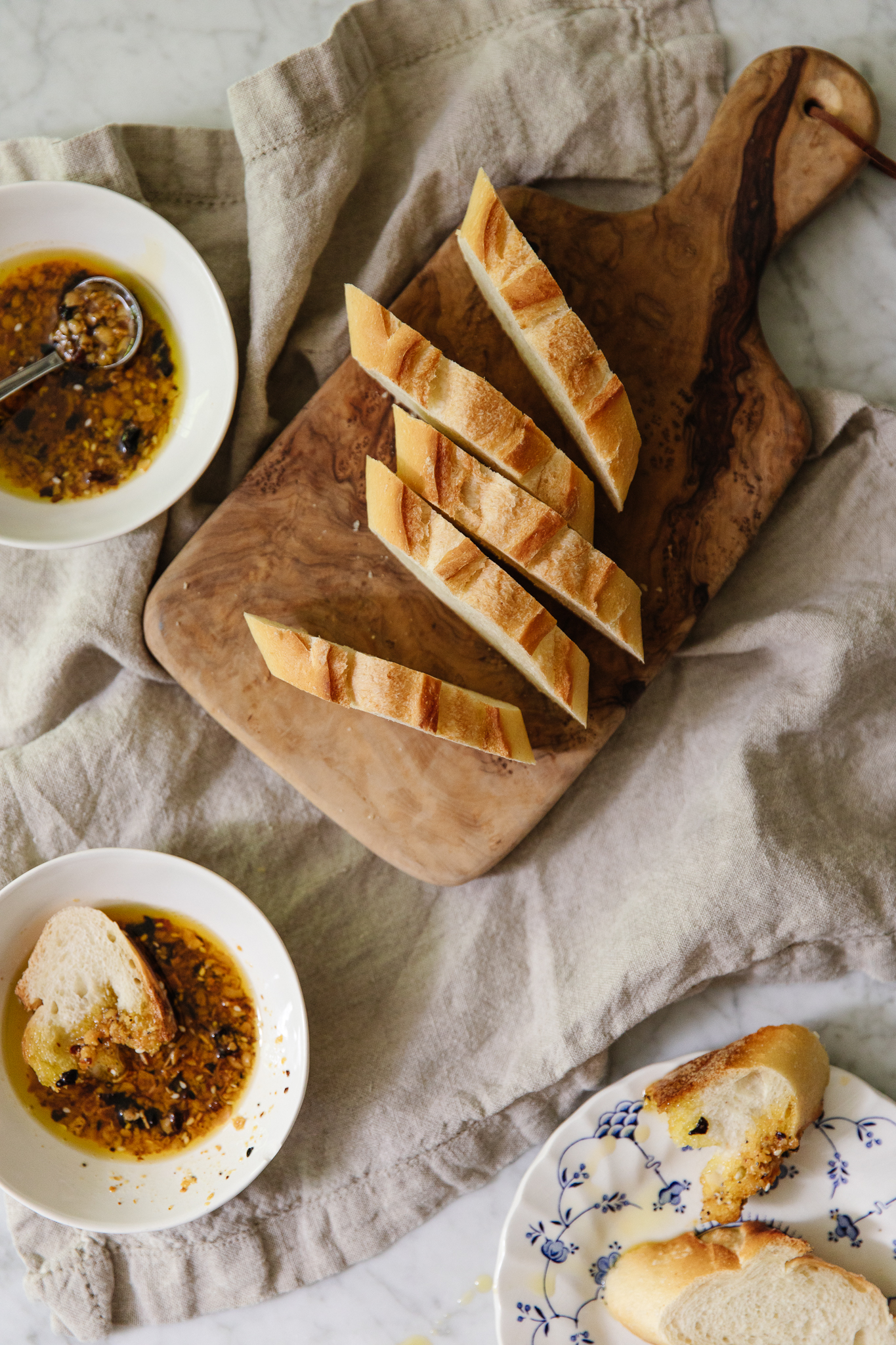Chris Loves Julia | Dipping oils and sliced bread on a wooden cutting board