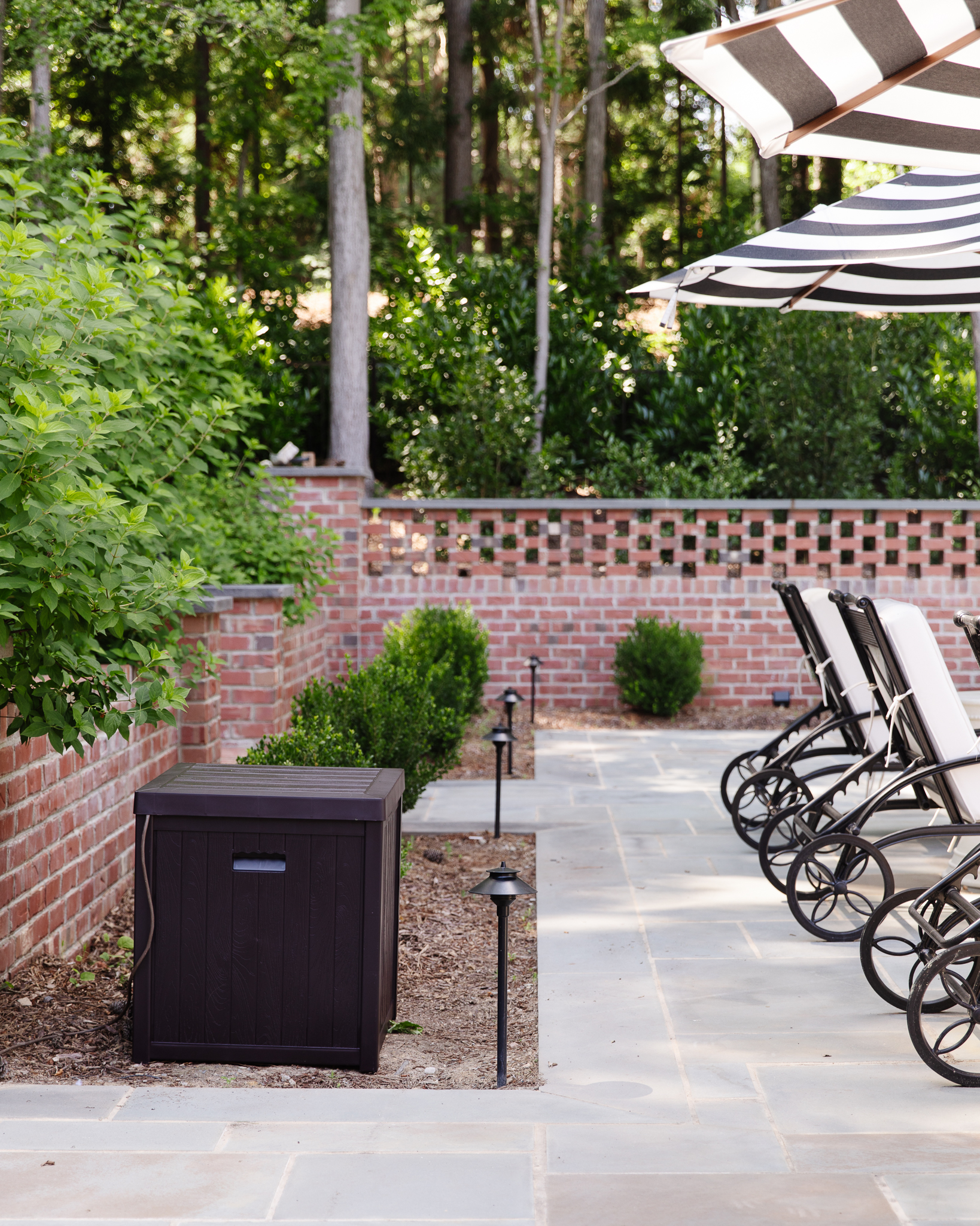 Chris Loves Julia | Backyard with dark brown deck box for storage