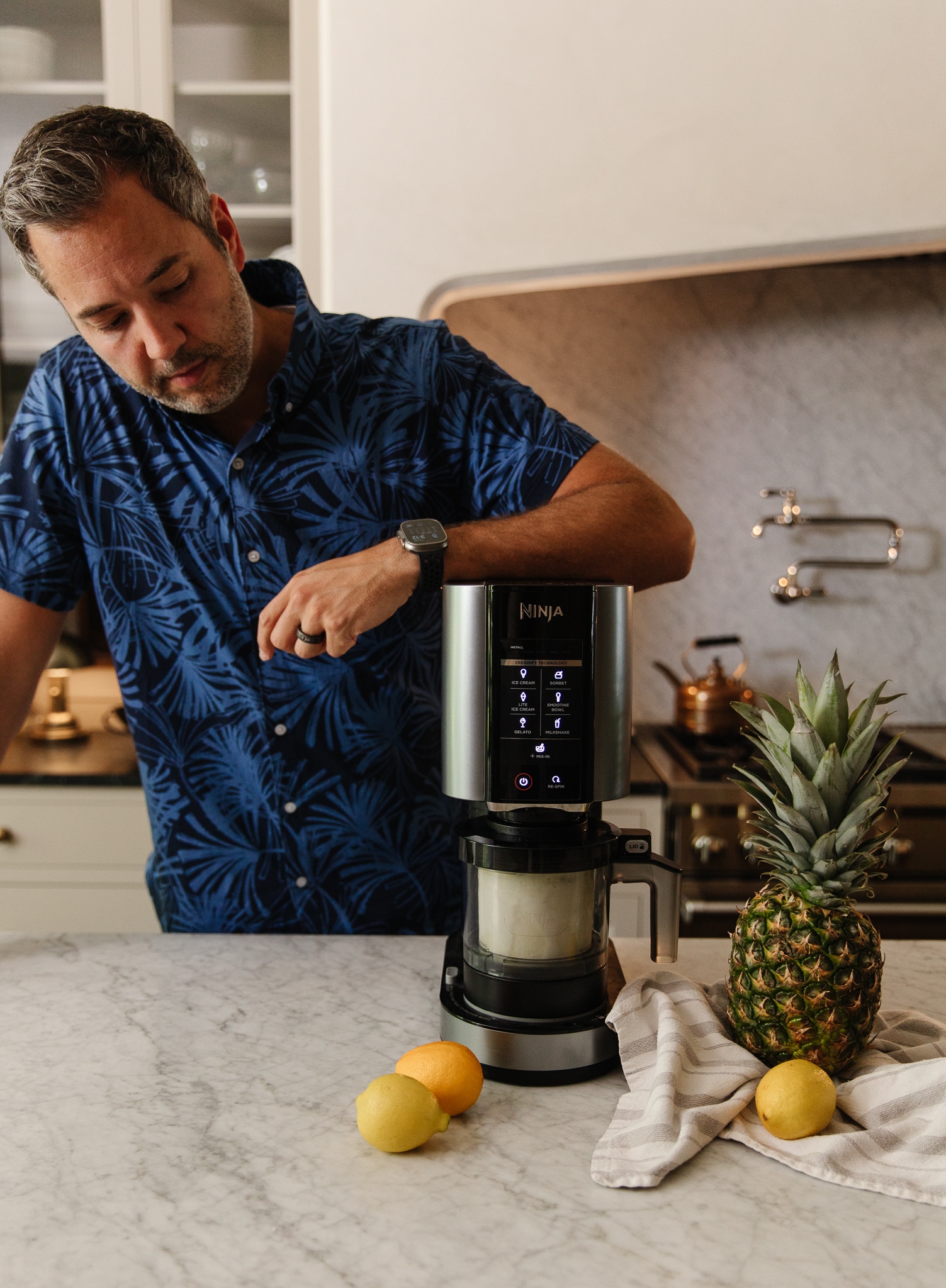 Chris Loves Julia | Chris leaning over a Ninja CREAMi to make a frozen virgin Piña Colada dessert