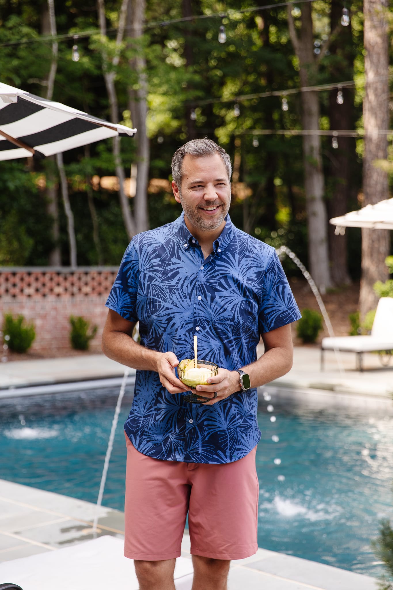Chris Loves Julia | Chris by the pool holding an ice cream cup filled with frozen virgin Piña Colada dessert