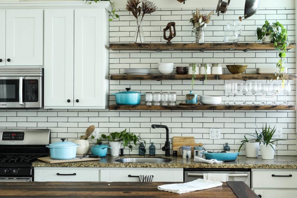 A modern kitchen with a farmhouse sink and open shelving.