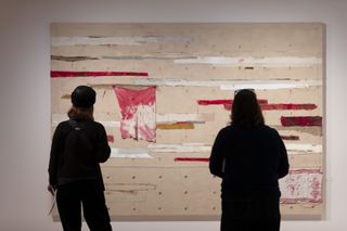 people looking at art on wall