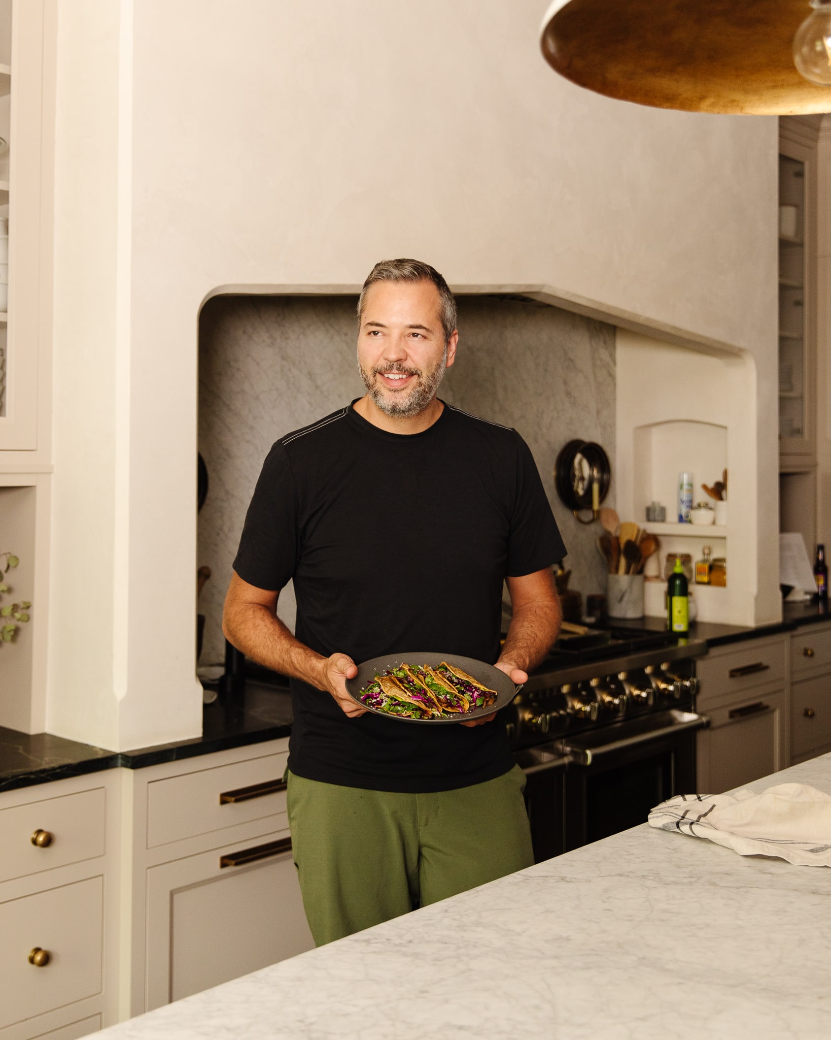 Chris Loves Julia | Chris holding a plate of vegan mushroom tacos