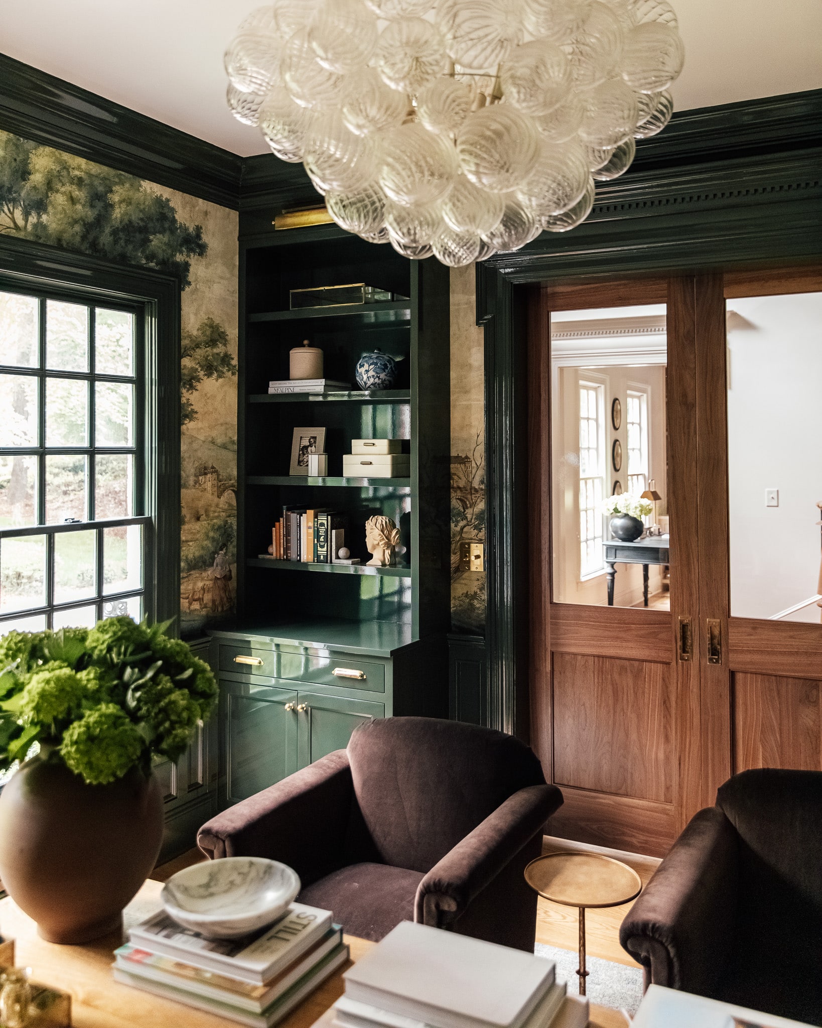 A dark green study with high-gloss paint on the bookcases
