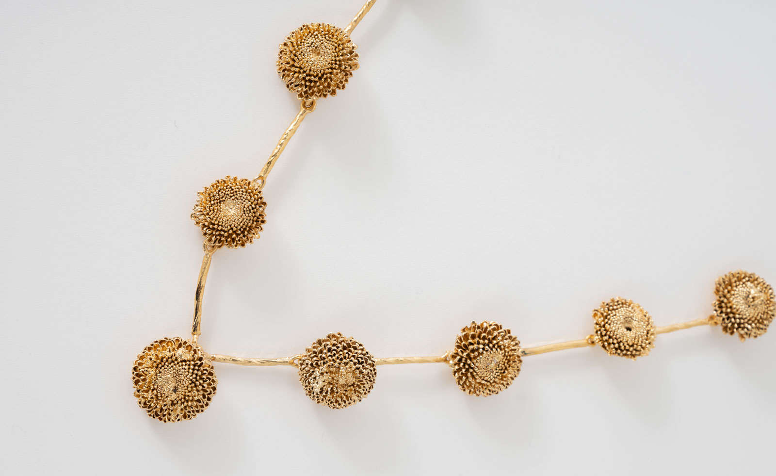 gold jewellery flowers on chain like a stem