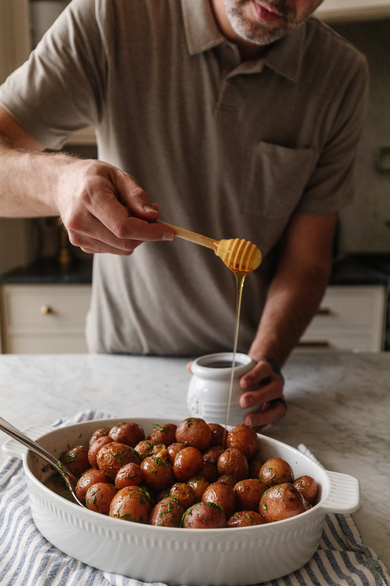 Chris drizzling honey over a dish of roasted red potatoes