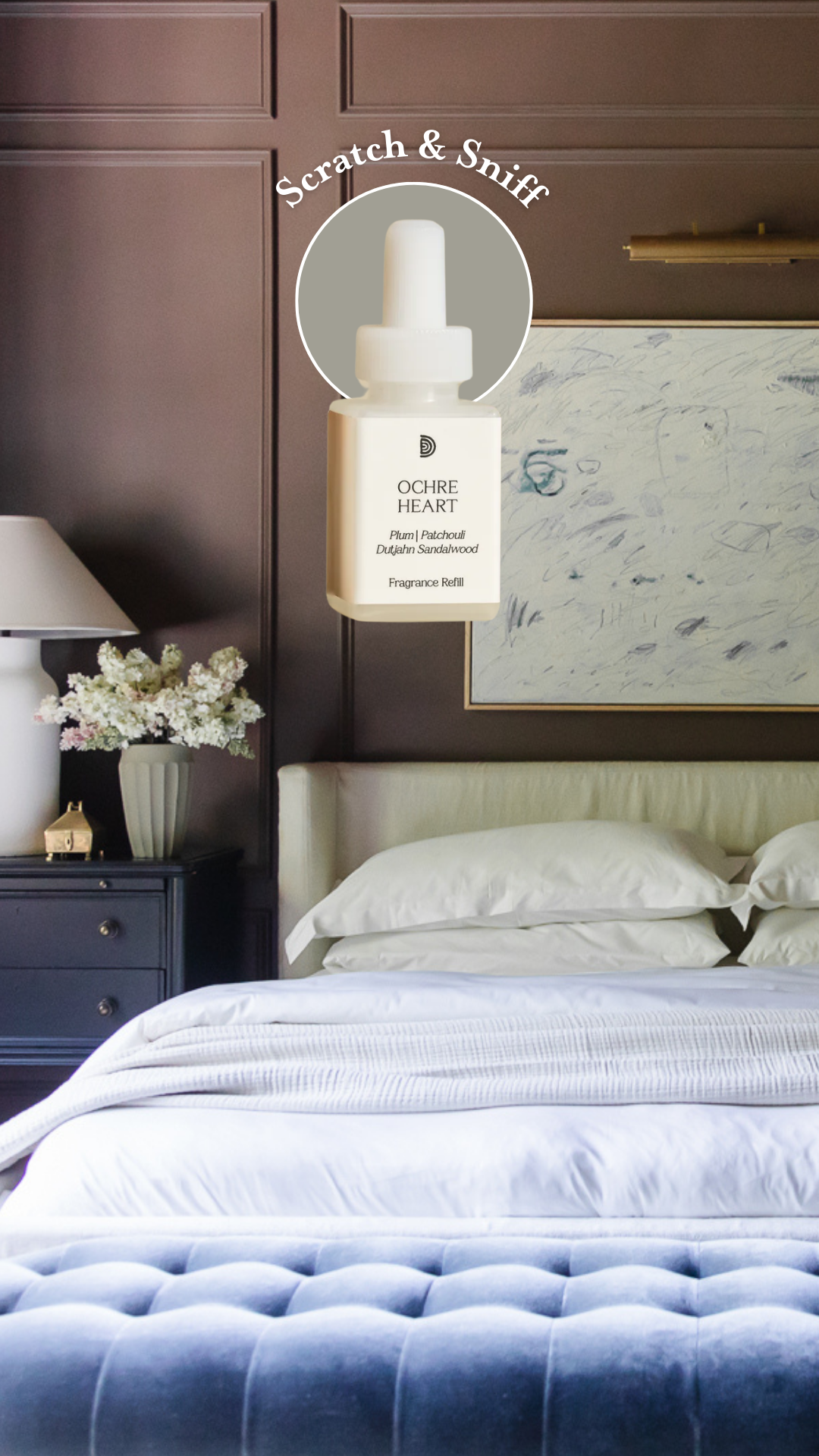 A dark, moody bedroom with a side table and vase of white lilacs with a superimposed Pura fragrance bottle: Scratch & Sniff Ochre Heart