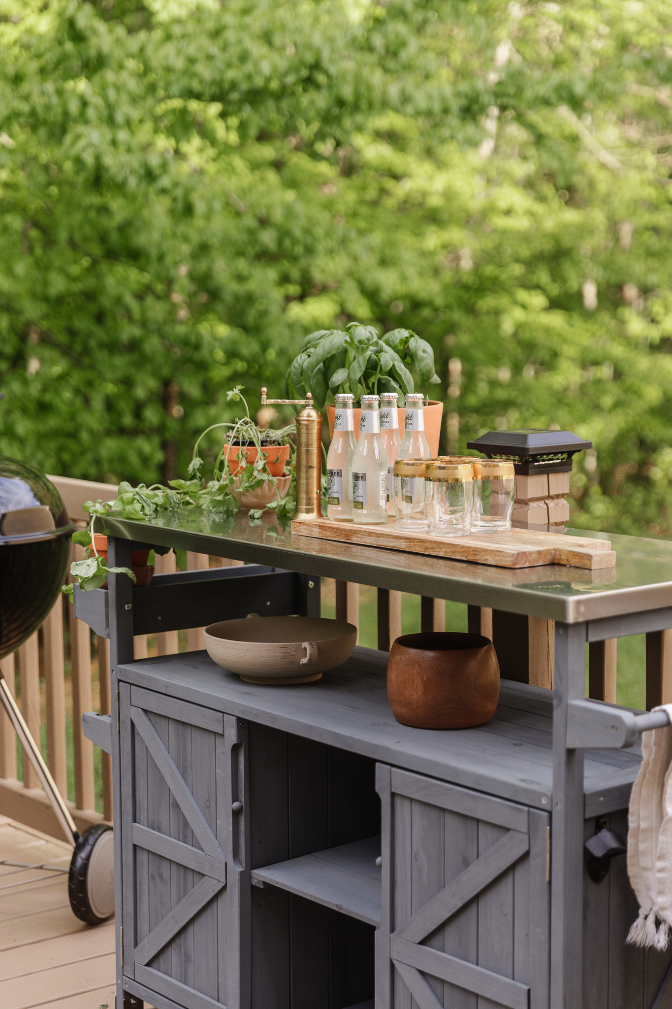Beverage station on a back deck with potted herbs and bottled sodas