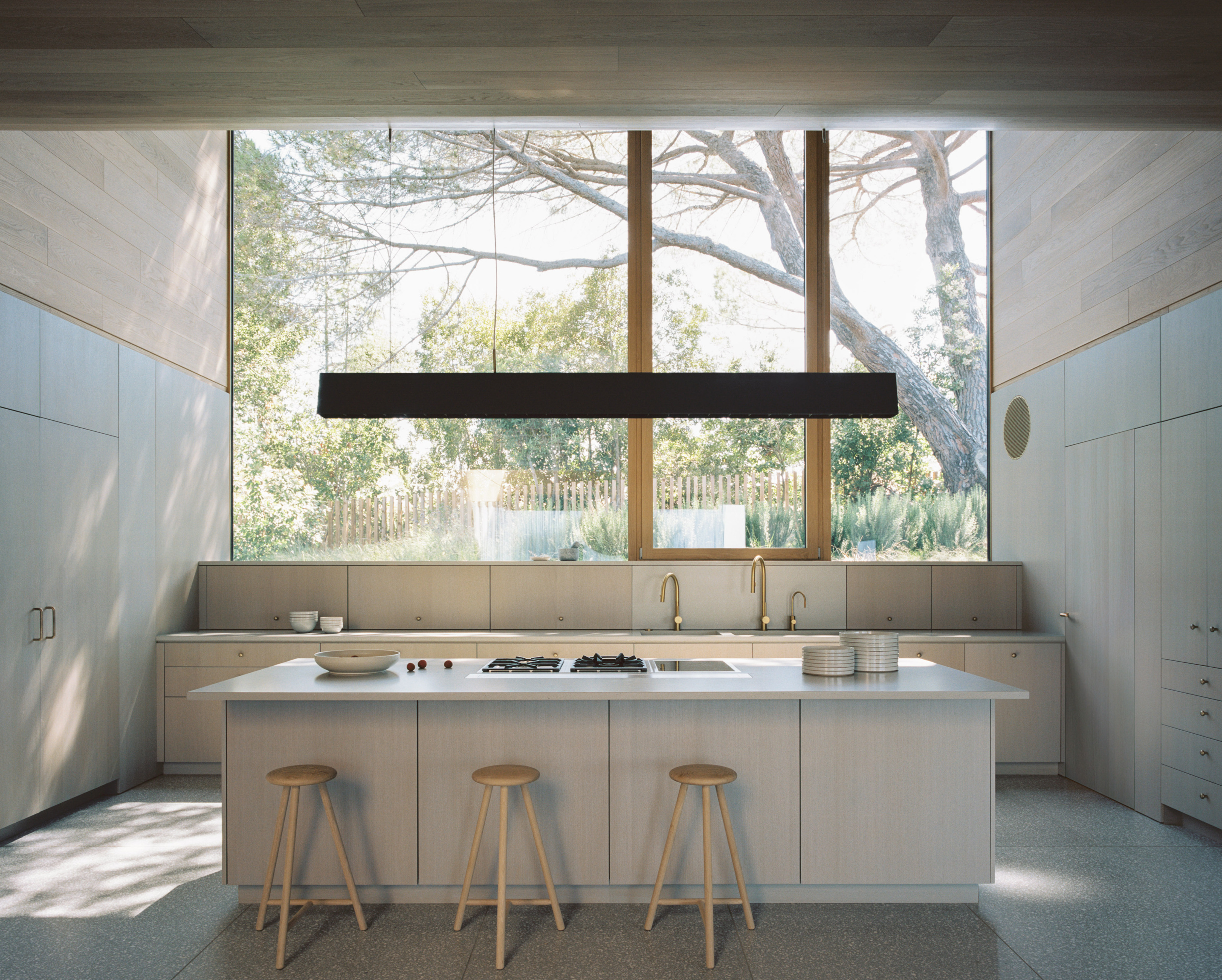 The bespoke kitchen with its monumental picture window framing the landscape