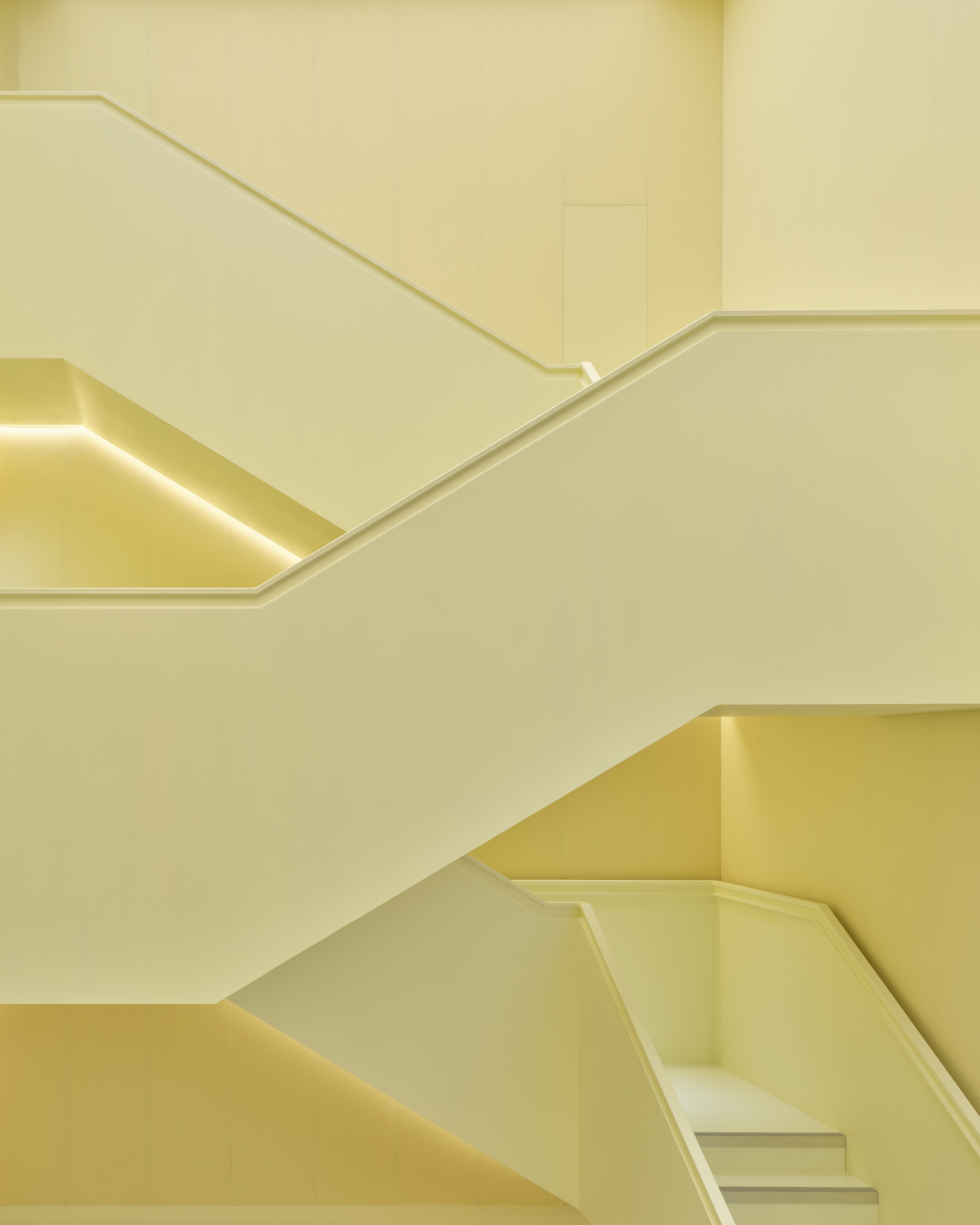 The domestically-scaled staircase is paired with fabric-covered walls to create a quiet, calm space