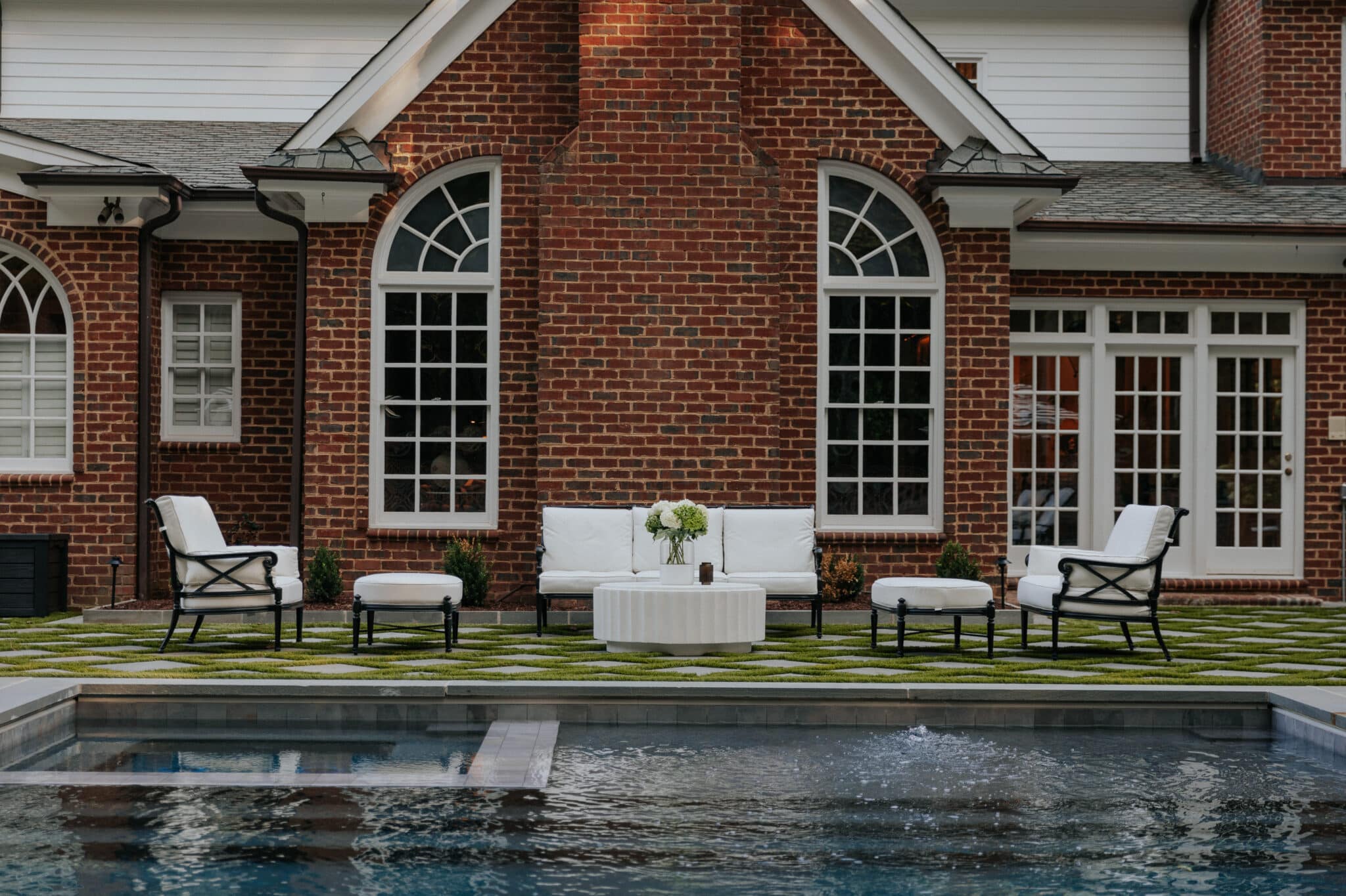 White-cushioned iron wrought furniture on a back patio