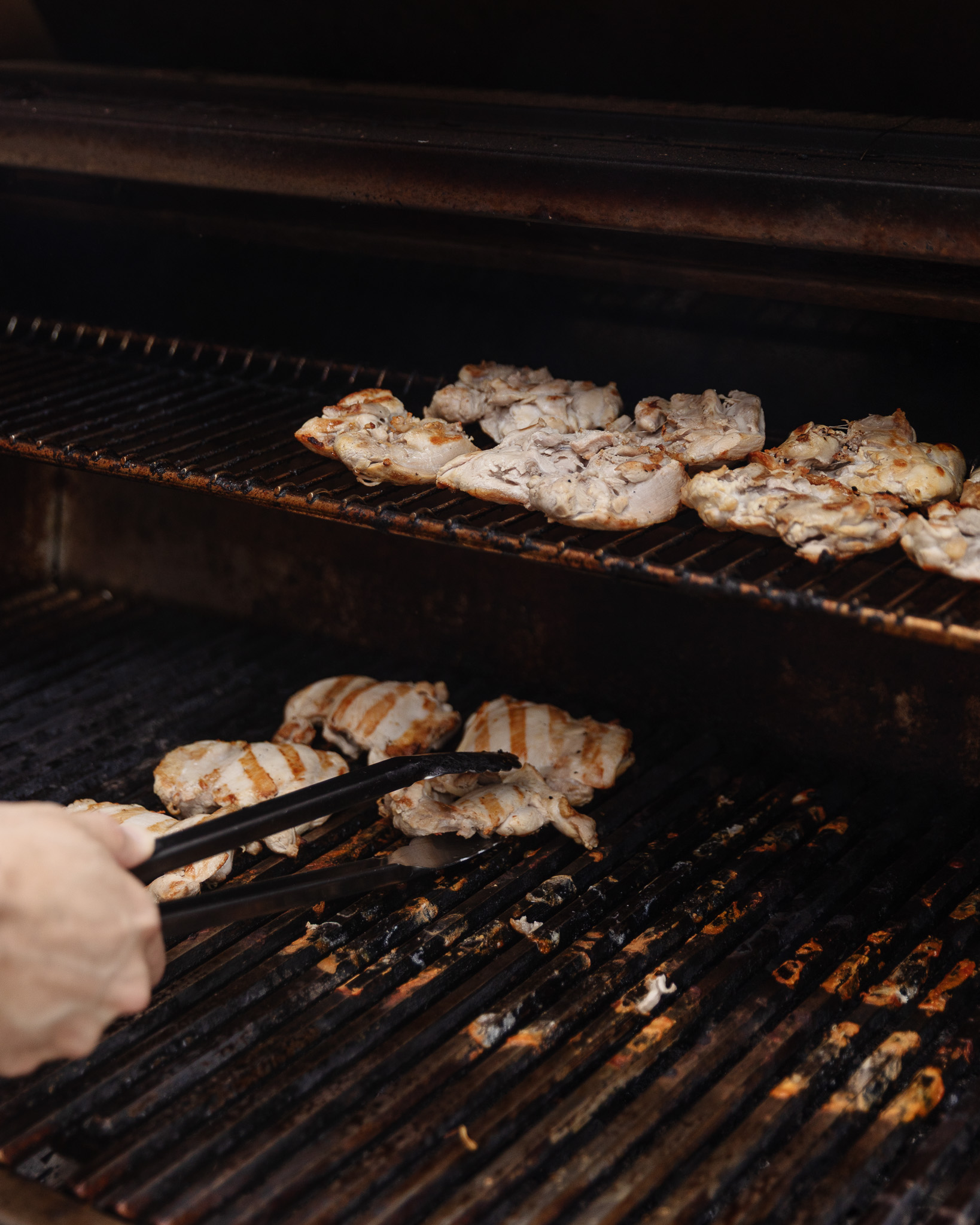 Chris turning chicken thighs on the grill