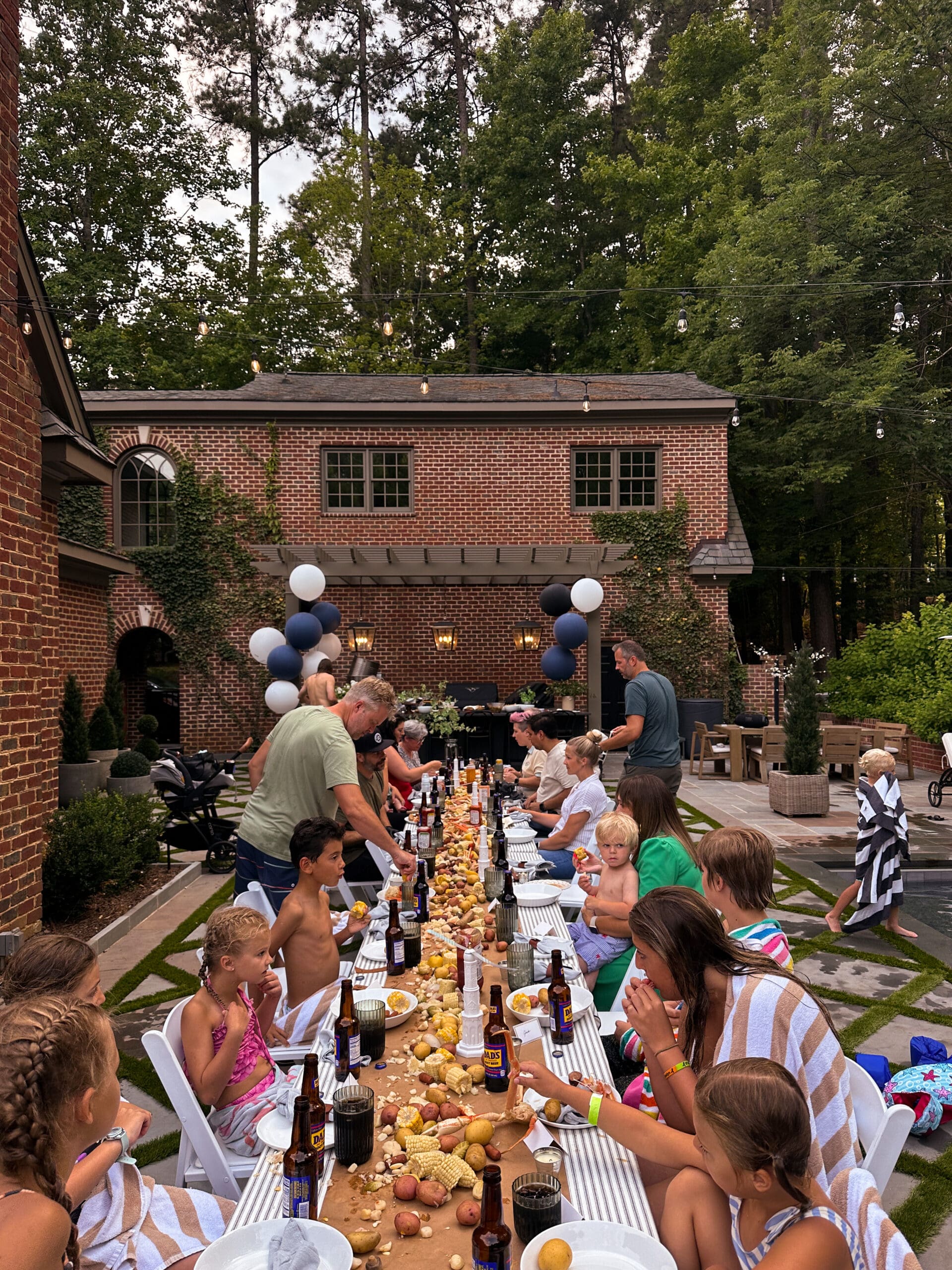 Backyard low-country boil on a long table in the backyard of the Modern Colonial brick home