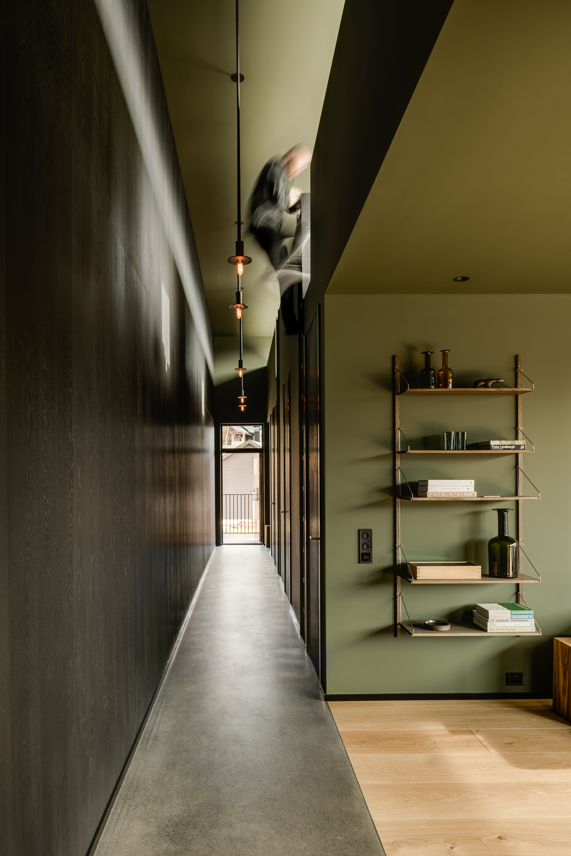 Looking back along the high-ceilinged entrance corridor to the bedrooms with the main living space on the right
