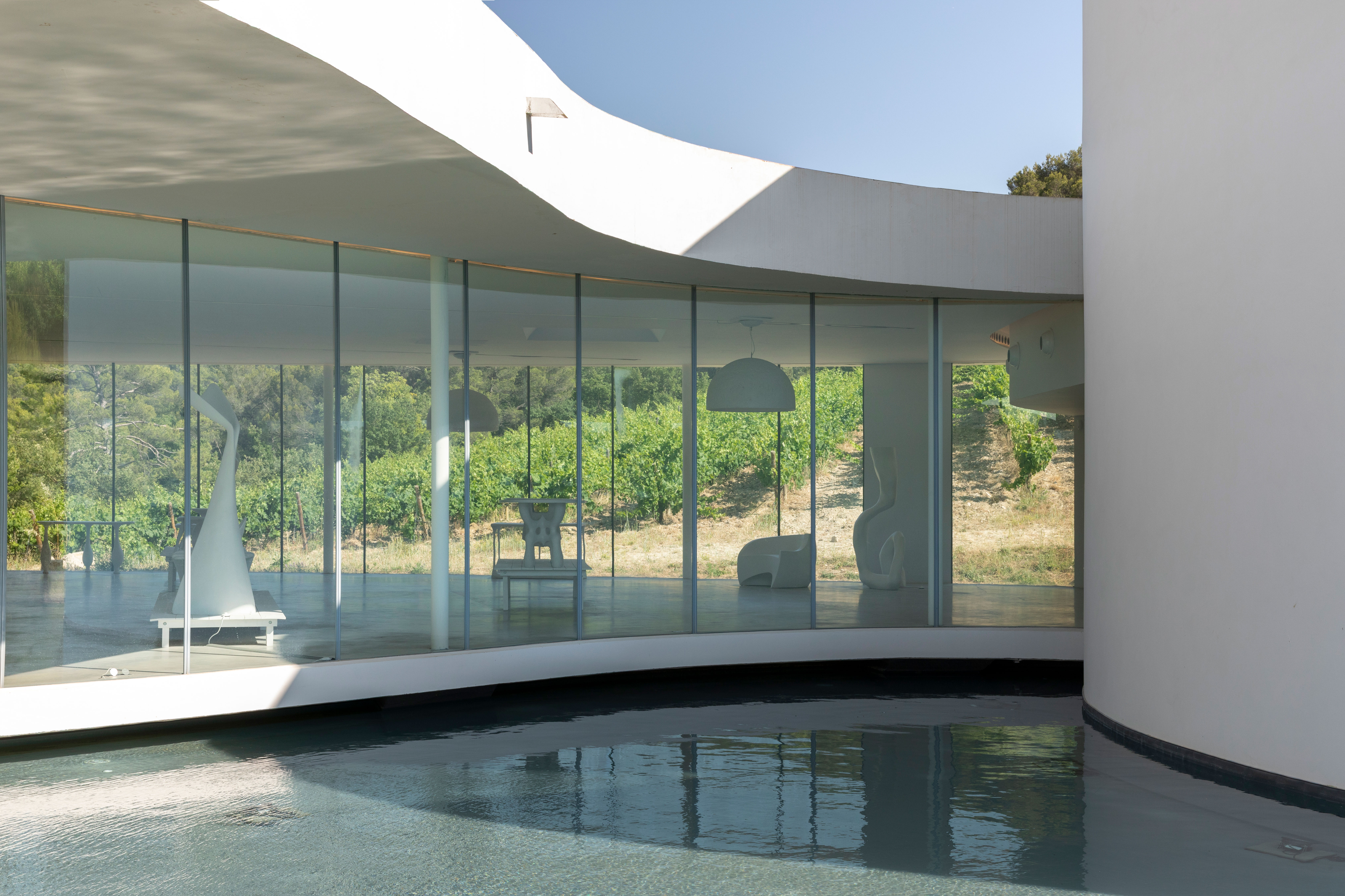 Chateau Lacoste glass pavilion with an exhibition of white furniture by Ralph Pucci
