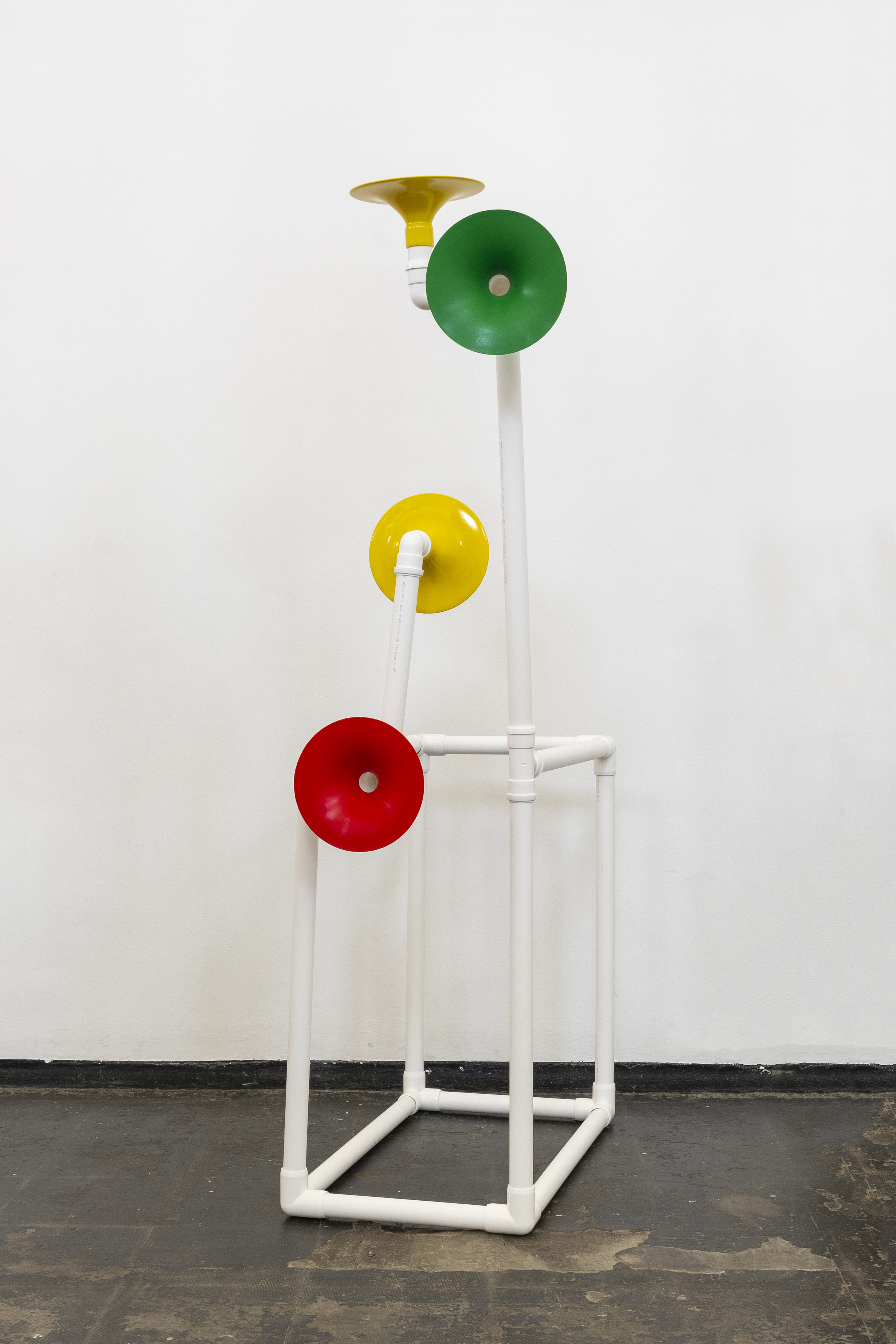 Installation in a former church made out of white pipes and colourful funnels