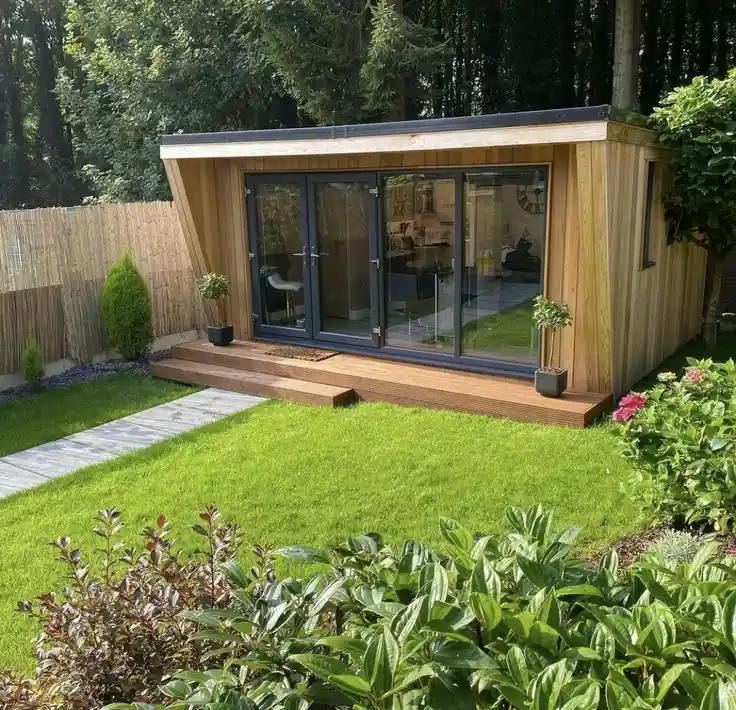 A modern garden outhouse with a small wooden deck