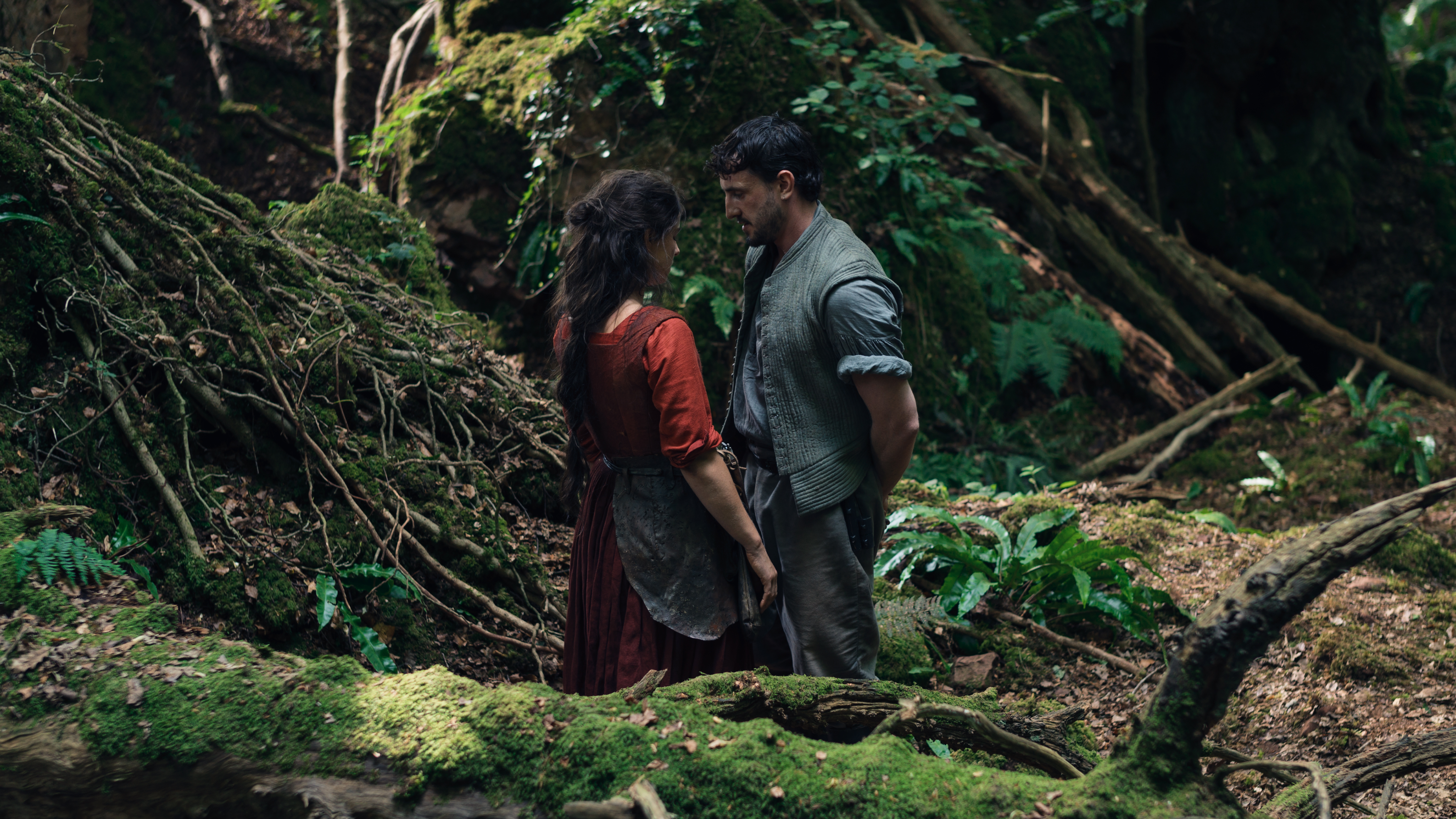 Actors Jessie Buckley and Paul Mescal as Agnes and William Shakespeare in the woods, in a scene from Hamnet