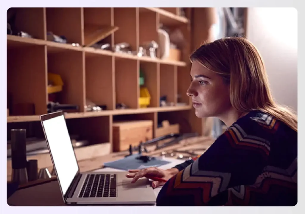 Designer working on a laptop in a workshop