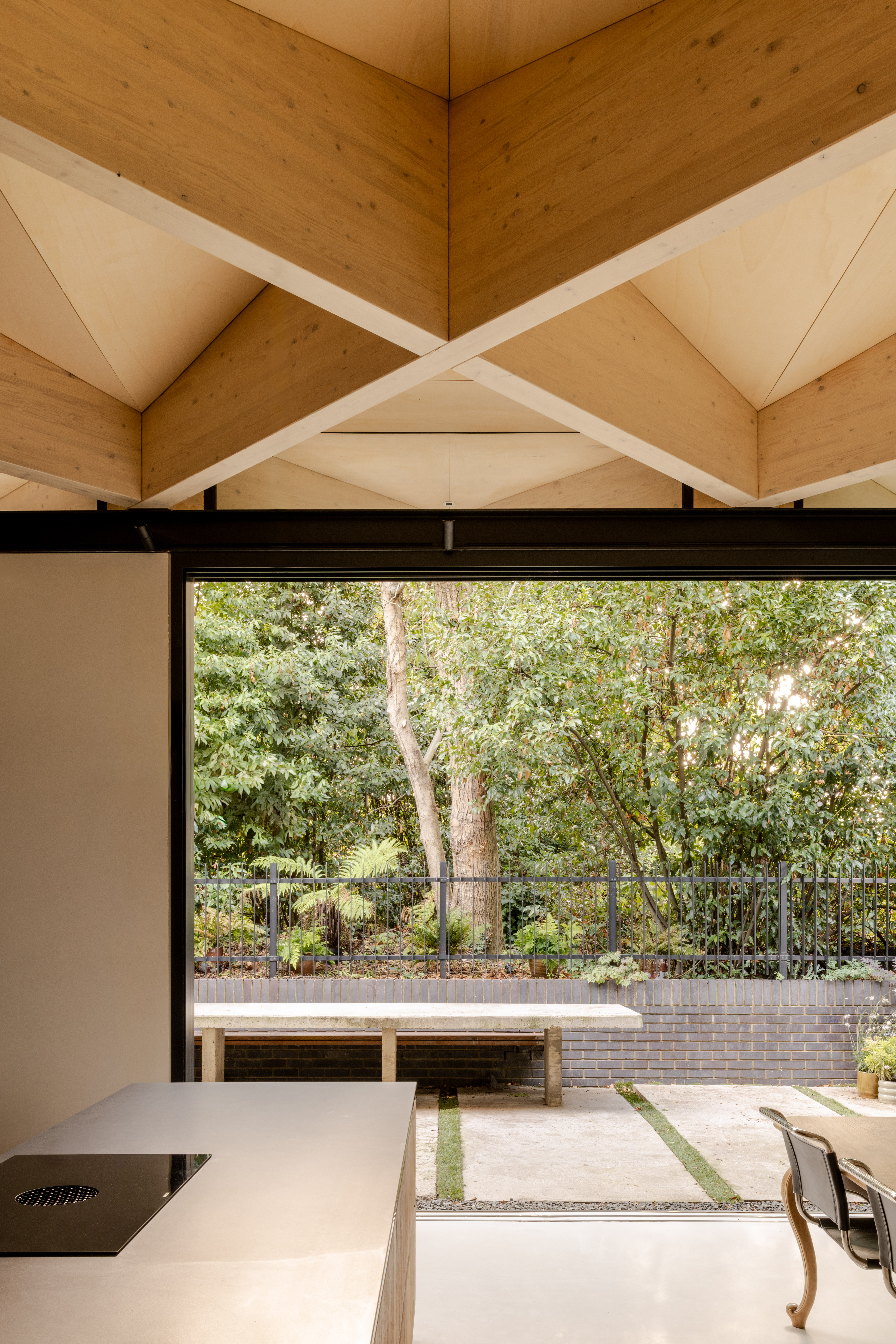 arbour house, a low, one storey home in a back year among trees, but with a distinctive angular roof