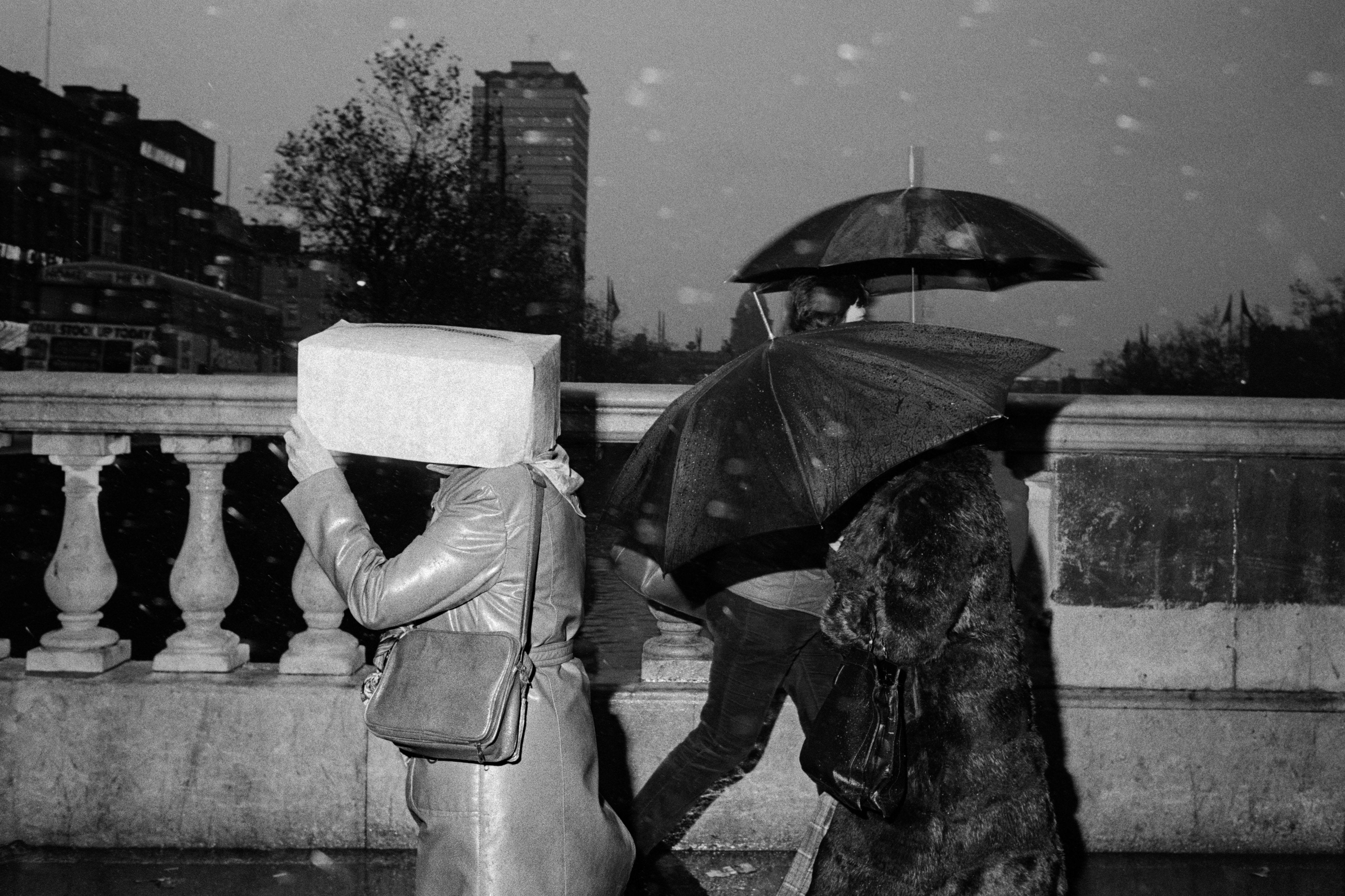 Martin Parr photograph of people crossing a bridge in the rain