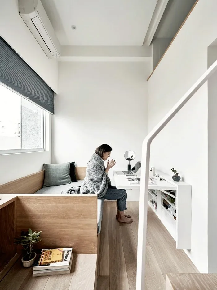 Cozy small studio apartment living area with built-in bench and workspace