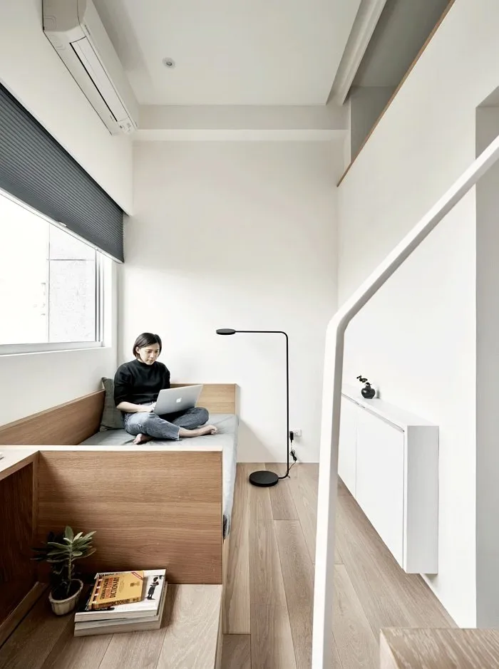 Small studio apartment sofa area with multifunctional seating and storage