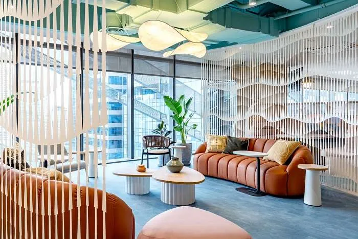 Biophilic lounge area with vertical slats, indoor greenery, and soft seating.