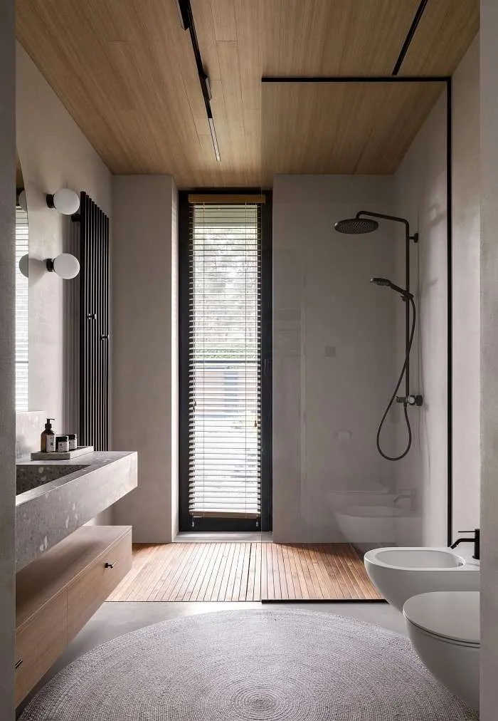 Bathroom with wood ceiling, walk-in shower, freestanding basin, and vertical window bringing natural light.