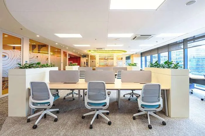Glass-enclosed workspace with ergonomic chairs and neutral finishes.