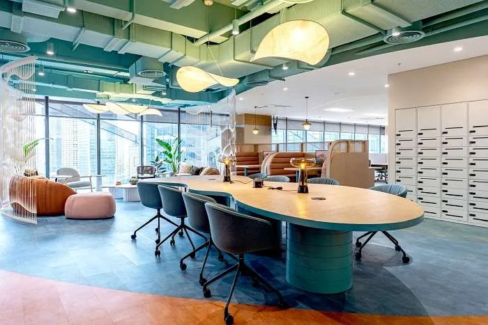 Open-plan workspace with flowing ceiling forms and collaborative desks in Manila.