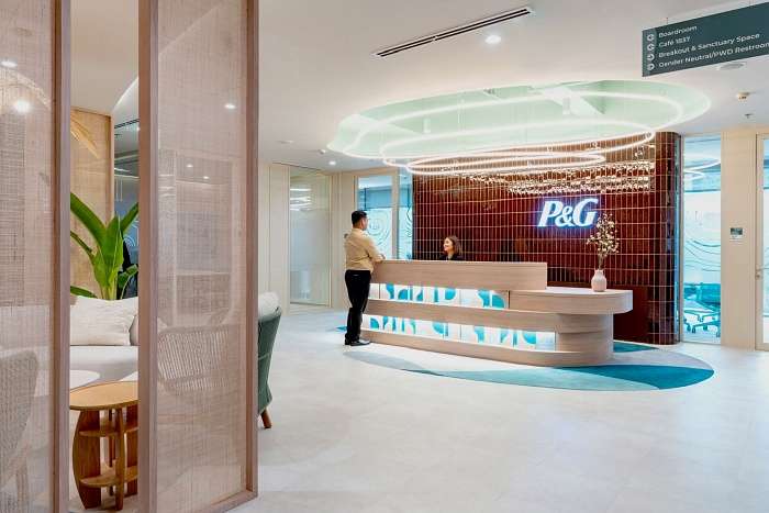 Reception area with curved white desk, layered textures, and soft lighting in a modern organic office.