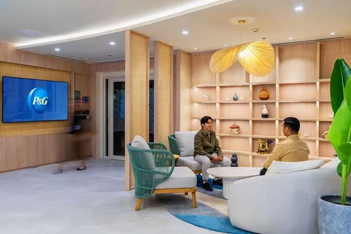 Lounge space featuring rounded sofas and organic office furniture with built-in shelving