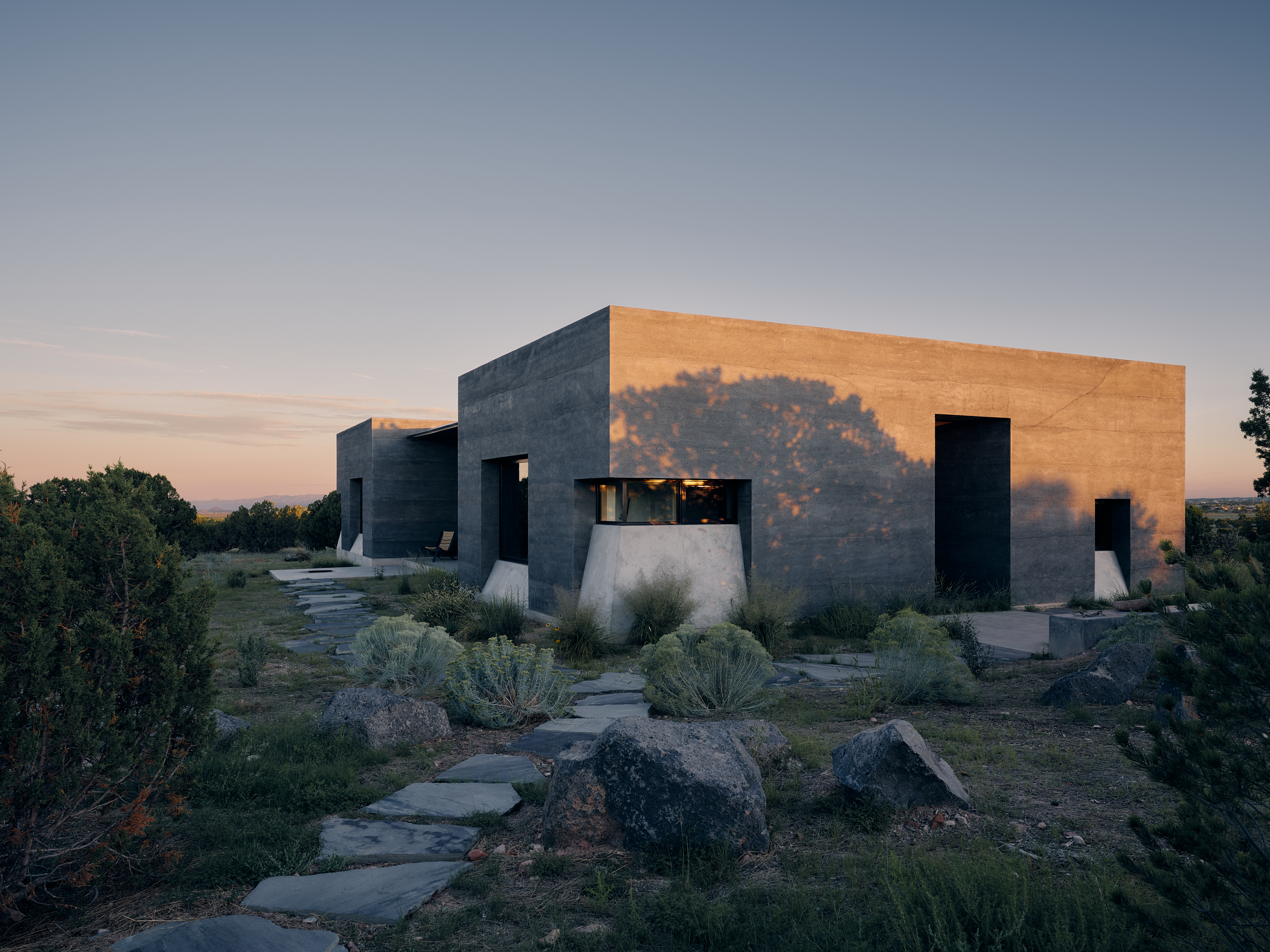 views of Sombra de Santa Fe, new mexico house, with dark, minimalist geometric volumes and clean walls and long nature views