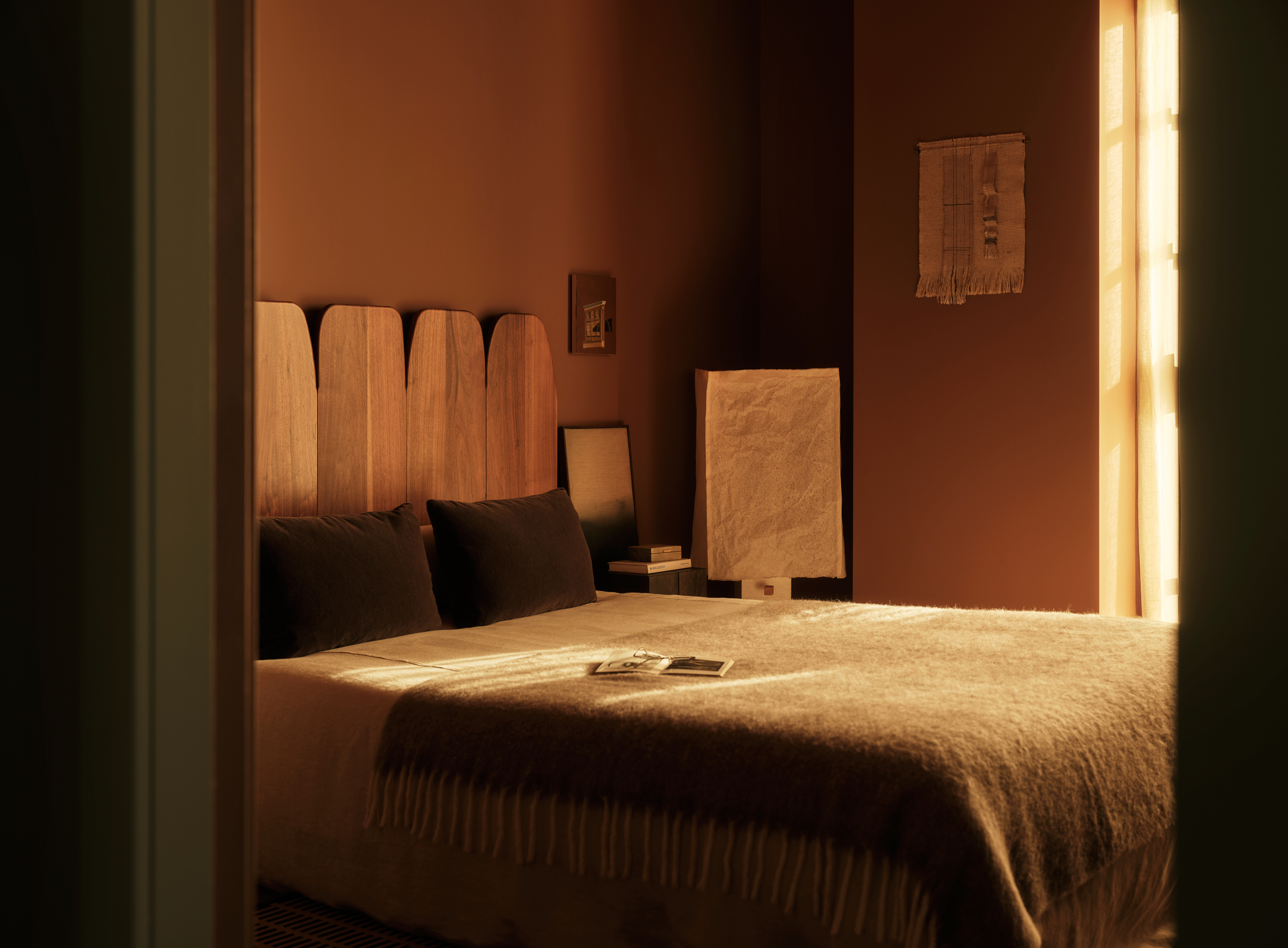 view of the Penthouse at The Founding by Conran and Partners, including timber based furniture and warm colours under moody lighting