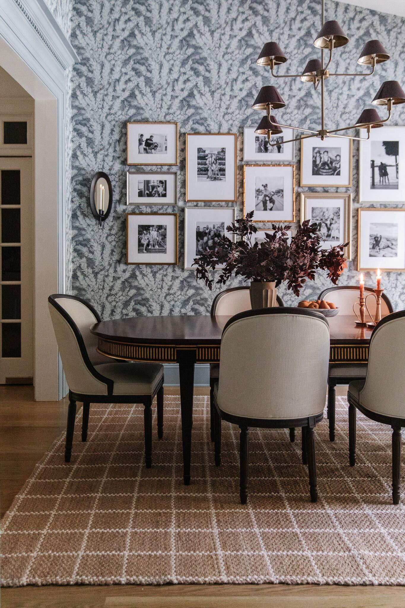 Dining room with gallery wall of black & white photos in mix-and-match gold frames