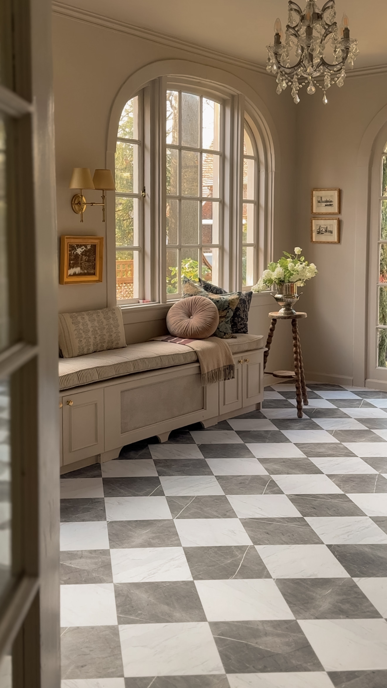 Beautiful gray and white peel-and-stick floor tile in a classic checkered pattern, enhancing the vintage charm of this cozy window nook.