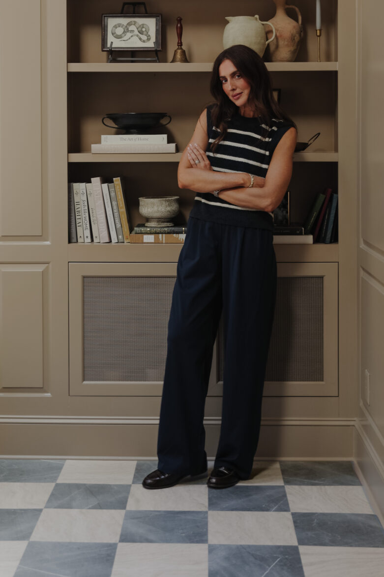 Slate & beige peel-and-stick tiles in a Living room with Julia Marcum standing in front of a built-in bookcase