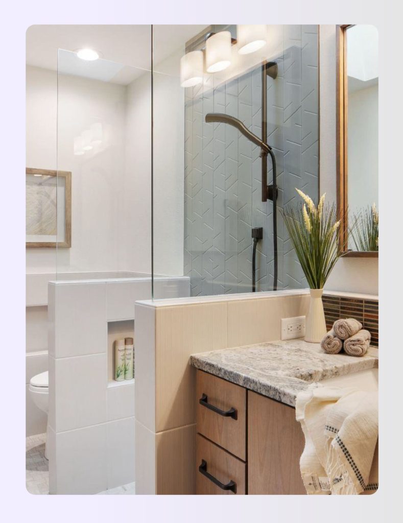 Narrow bathroom with a low half-wall partition separating toilet and shower zones Narrow bathroom with a low half-wall partition separating toilet and shower zones