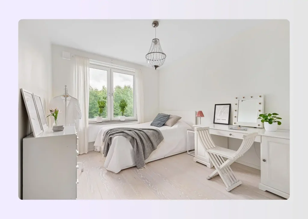 Bedroom with rug-defined sleeping zone and compact desk area in the far corner