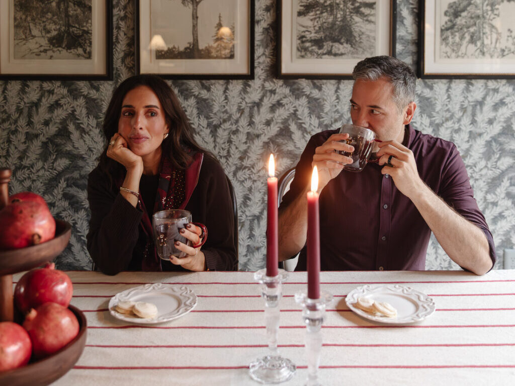 Chris & Julia enjoying warm drinks at a pretty red & white decorated dining room table