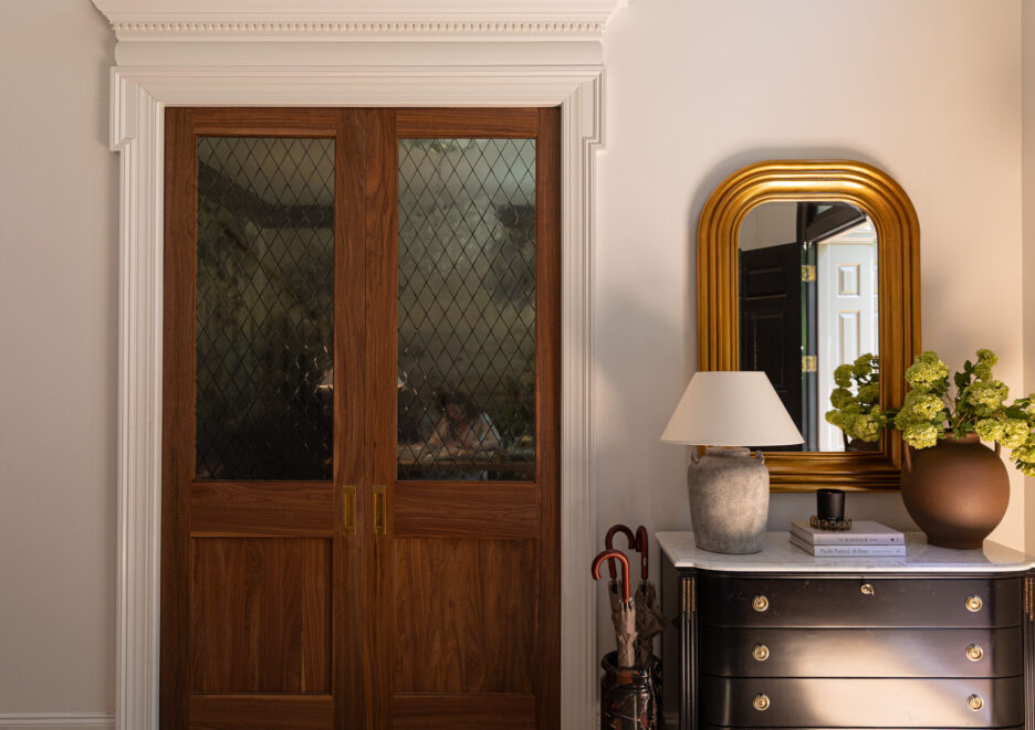 Door with wooden frame and diamond-patterned glass panels in a cozy home entryway.